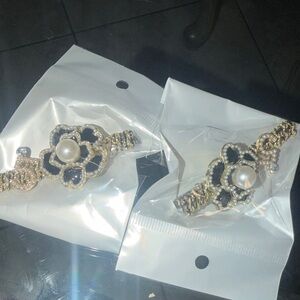 A pair of Elegant Gold and Black Floral Pearl hair clips